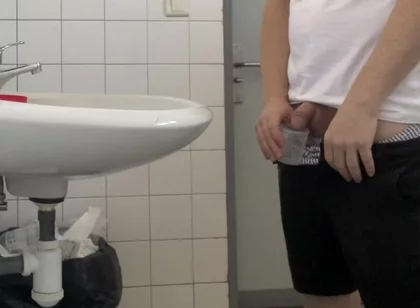 Guy Taking a Urine Sample in Hospital Toilets