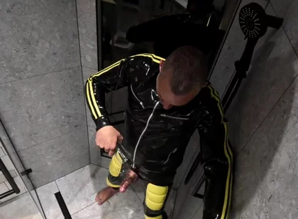 Rubber Man Pisses with Uncut Cock